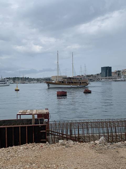       Boat docked in a harbor with overcast skies.
  