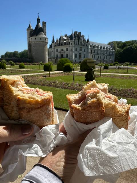 Sandwiches held up with a historic castle in the background.