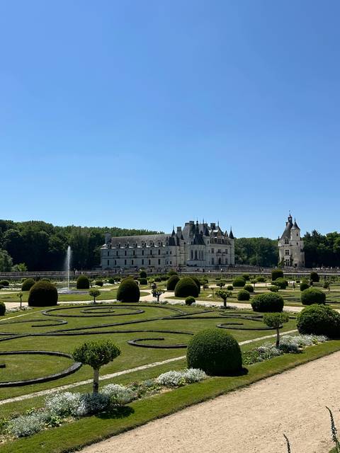 Gardens with a historical chateau in the distance.