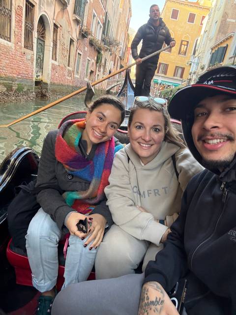       People enjoying a gondola ride in Venice.
  