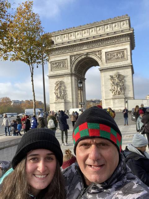 Two people posing in front of a famous arch.
