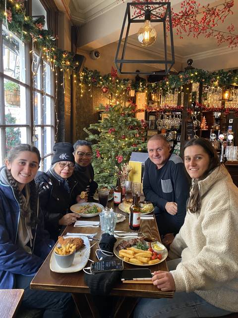       Family dining at a Christmas-decorated restaurant.
  