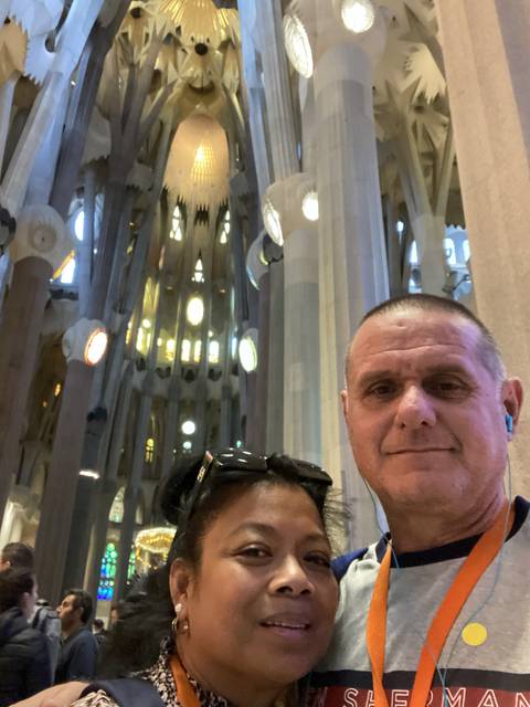 Two people smiling inside an elaborate building.