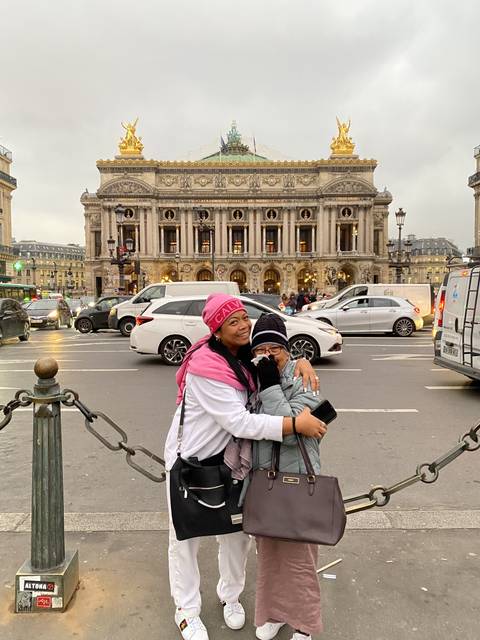       Two people posing in front of an ornate building.
  