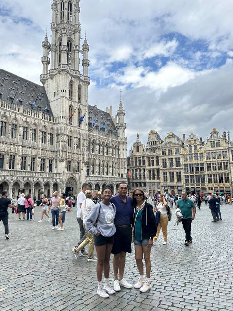 Tourists in a city square with historic buildings.