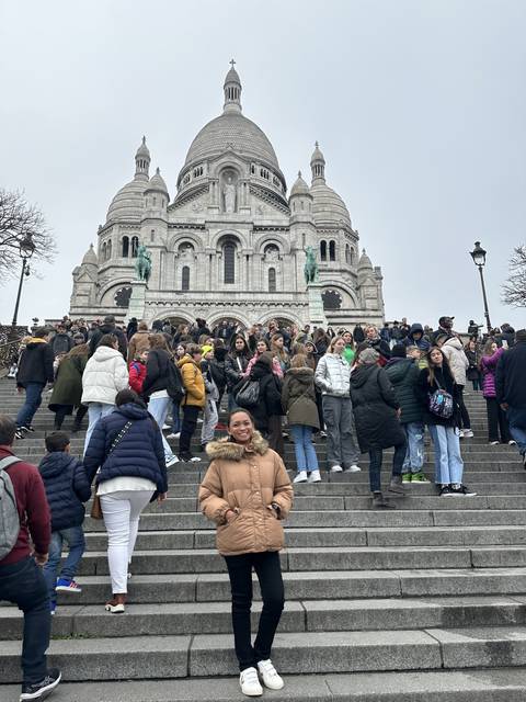 Crowd of people standing on steps in a historic area.