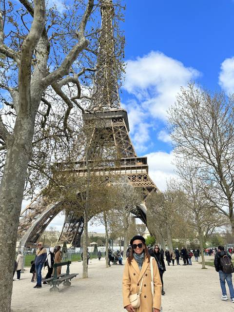 Person posing near the Eiffel Tower.