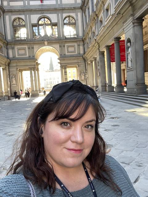       Person in front of an architectural scene with columns.
  