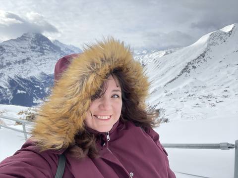       Person in winter clothing with snow and mountains.
  