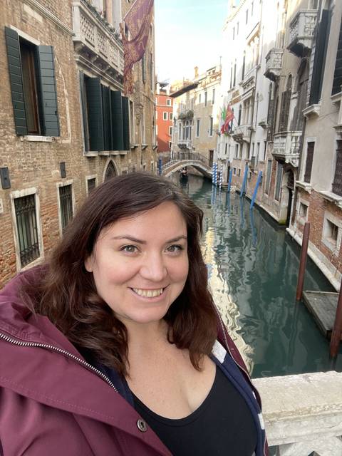       Person with a canal view and Venetian architecture.
  