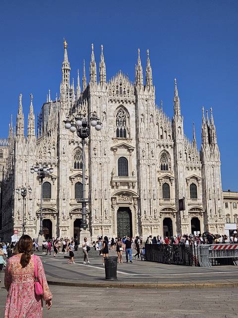       A busy street in front of a grand cathedral.
  