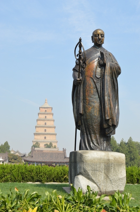 Statue in front of a pagoda tower.