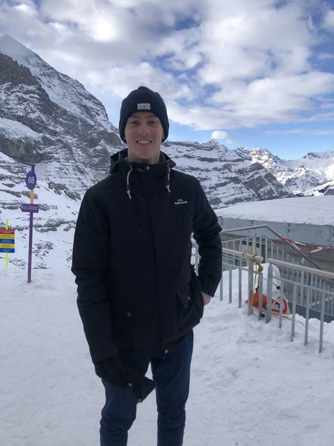 Person standing on a snowy mountain slope.