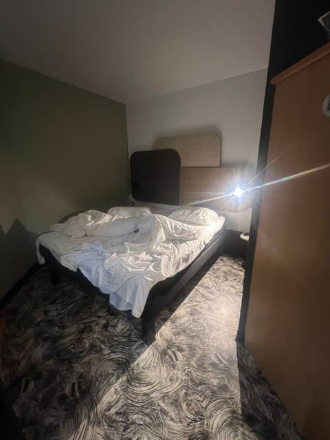 Interior of a bedroom with bed and nightstand.