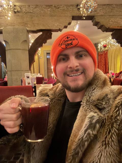 Person holding a drink in a warmly decorated room.