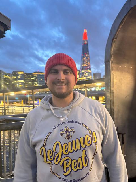 Person posing with nighttime city lights in the background.