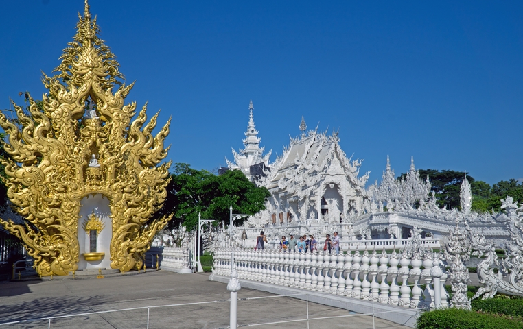 White temple complex with golden sculptures.
