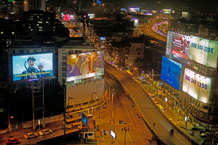 Cityscape with illuminated billboards and traffic at night.