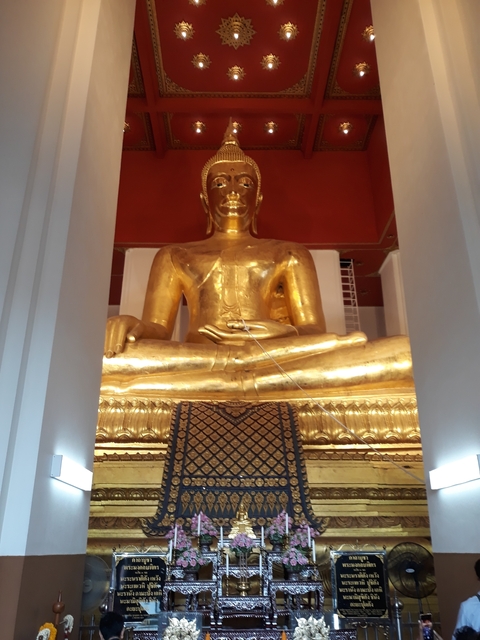       Golden Buddha statue seated in a temple.
  