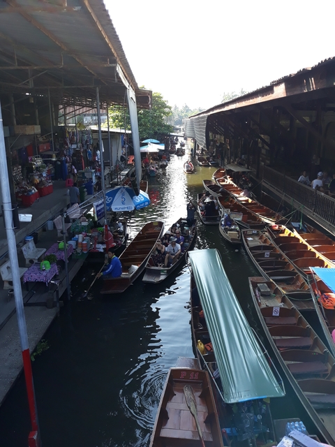 Busy floating market with several boats and people.