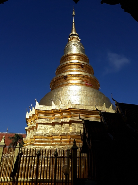       Golden stupa shining against a blue sky.
  