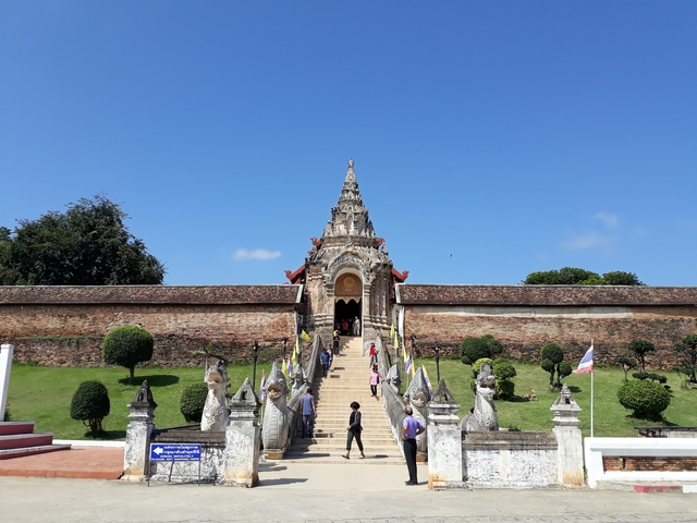       Entrance to a historic temple with people visiting.
  