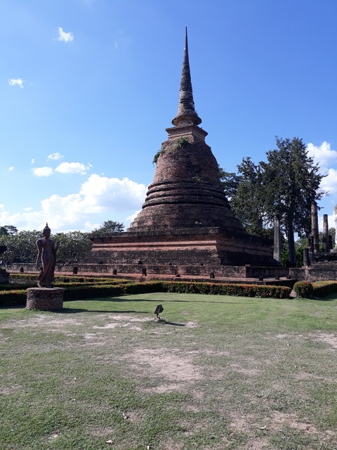 Ancient brick stupa under a clear blue sky.