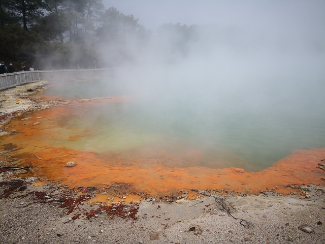 A geothermal hot spring with colorful mineral deposits.