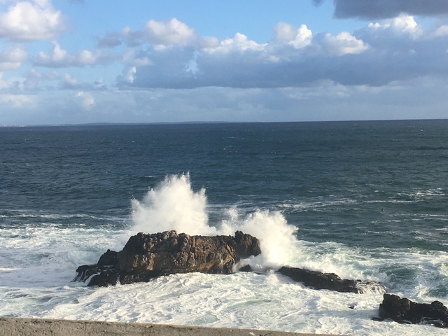       Waves crashing against a rocky shore.
  