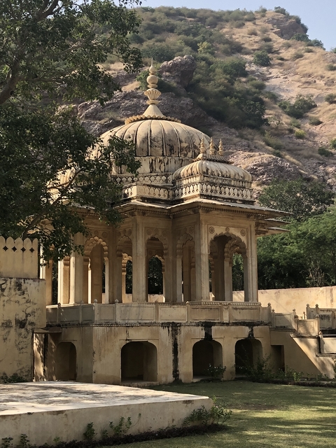       Ornate pavilion with arches set against a rocky backdrop.
  