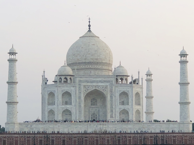       The Taj Mahal with numerous visitors at the forefront.
  