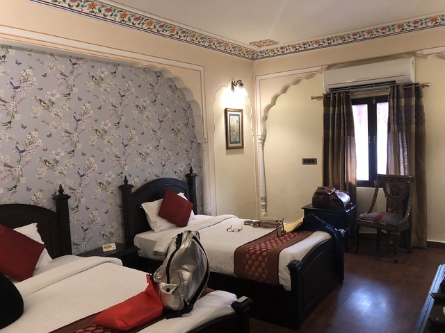       Hotel room with twin beds and colorful decorations.
  