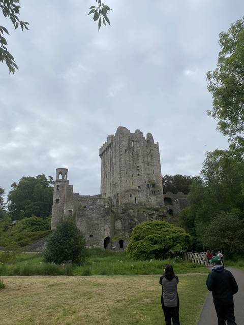 Person photographing an ancient stone castle.