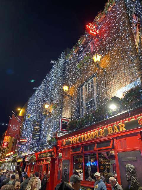 Night scene of a decorated and lit street with people.