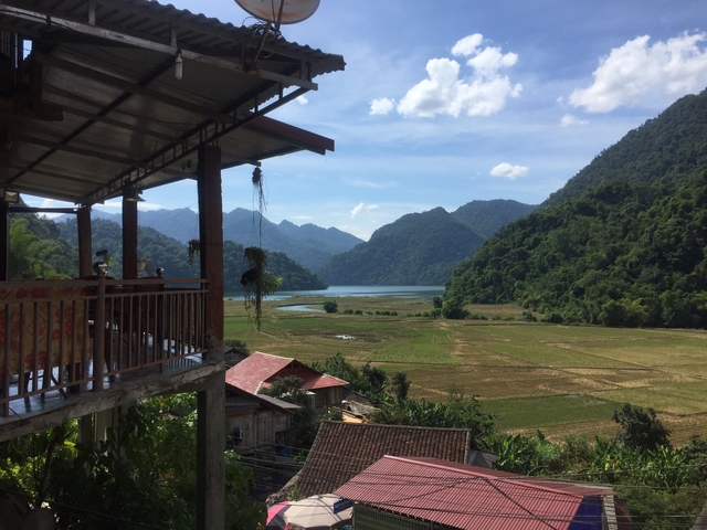 Scenic view from a balcony overlooking fields and mountains in Vietnam.