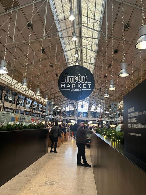       Interior of Time Out Market with people walking.
  