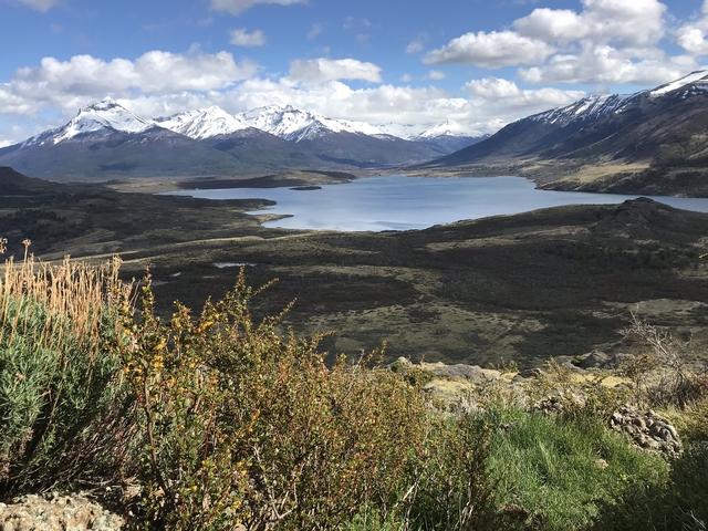       Scenic landscape with lake and mountains.
  