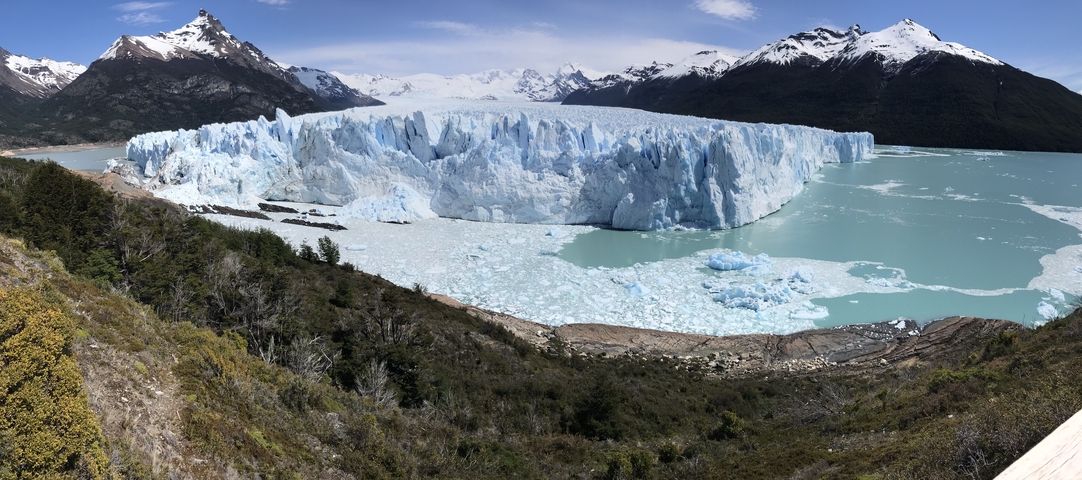       Panoramic view of Perito Moreno Glacier with surrounding mountains and lake.
  