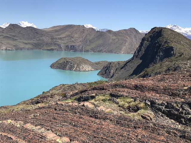       A turquoise lake surrounded by mountains.
  