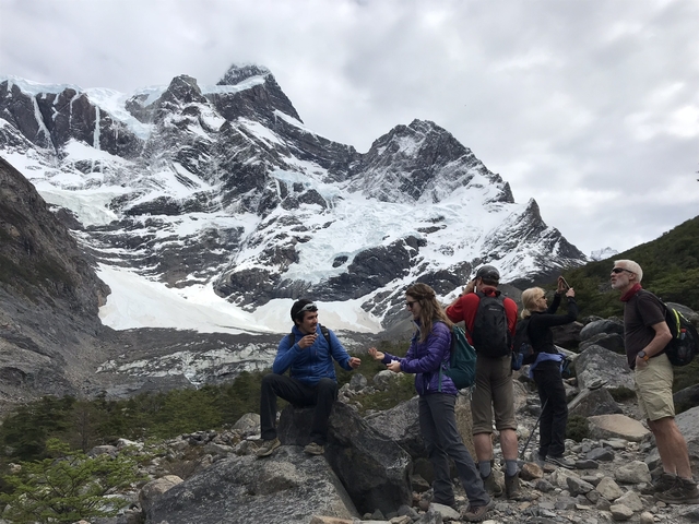       Group of hikers with snowy mountains in the background.
  