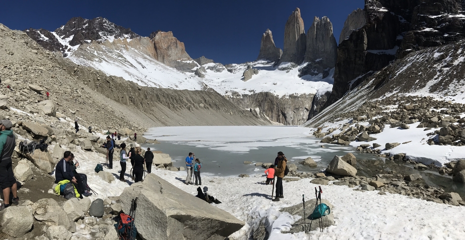       People enjoying a snowy landscape with mountains.
  