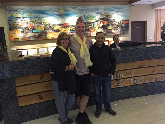 Three people posing together in a hotel lobby.