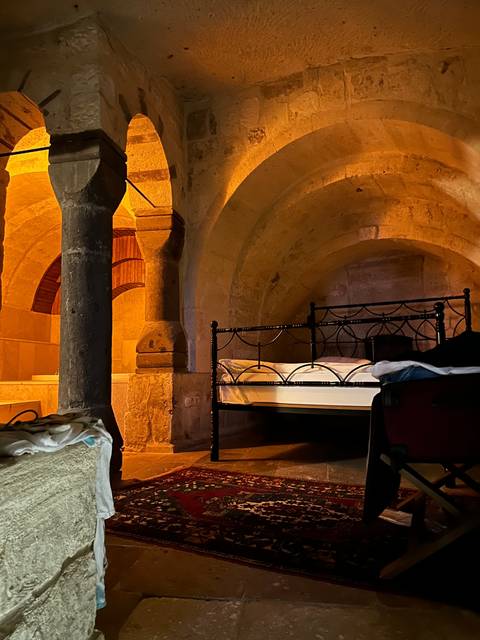       Interior of a stone room with bed and ambient lighting.
  