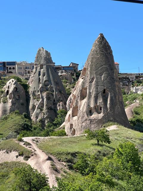       Cave dwellings in a unique rocky landscape under clear blue skies.
  