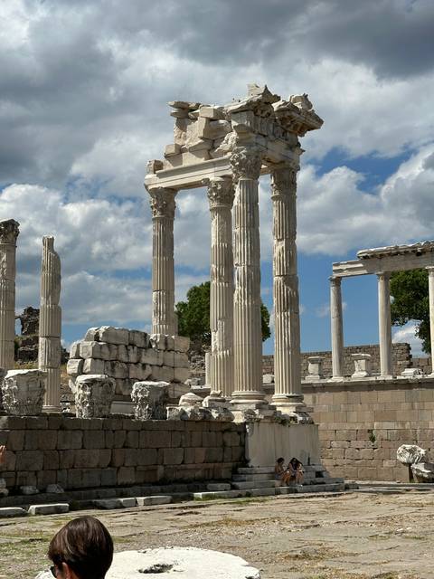       Ancient ruins with tall columns and tourists.
  