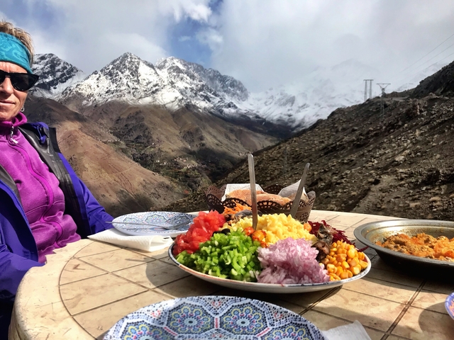 Outdoor dining table with food overlooking mountains.