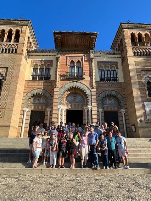       Group posing in front of a historic building.
  