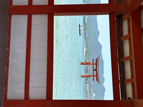       Red torii gate on a lake with mountains in the background.
  