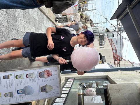       Person holding a giant pink cotton candy.
  