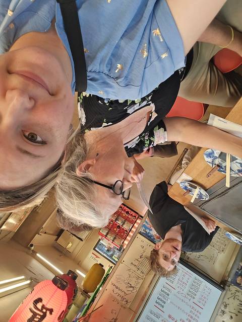       People at a food venue with menus.
  